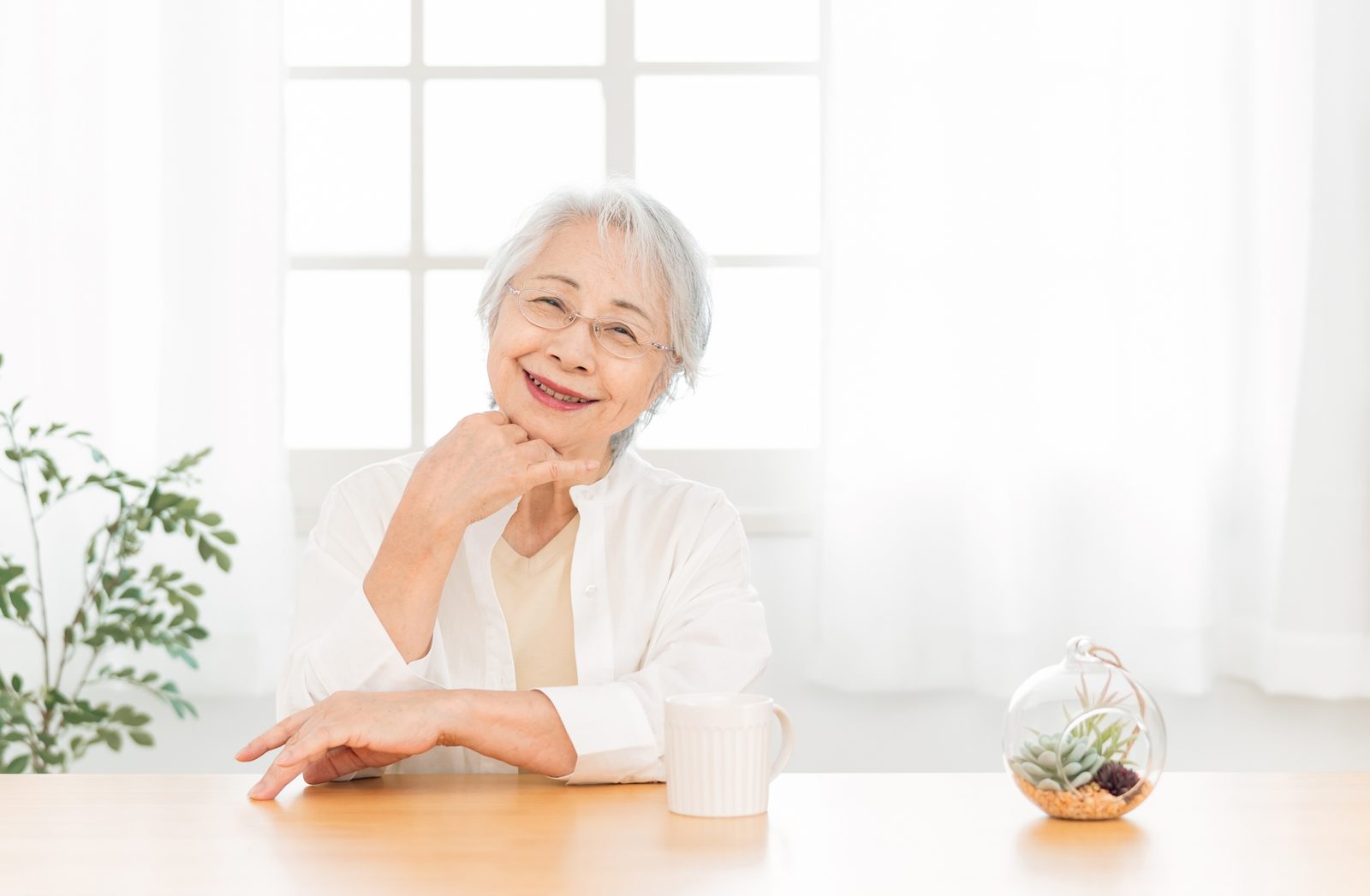 明るい室内で笑顔を見せる高齢女性