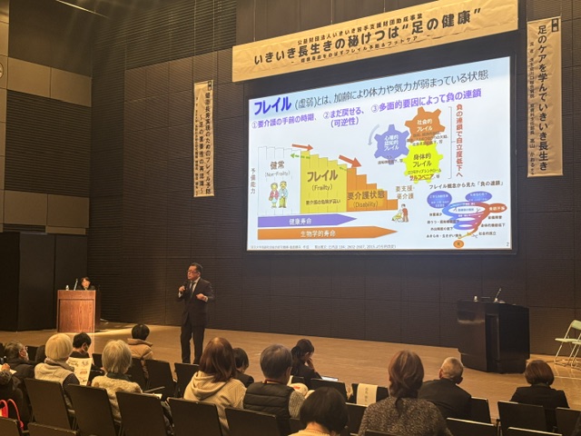 フレイルの考え方を示すスライドを見ながら講演を聴く参加者