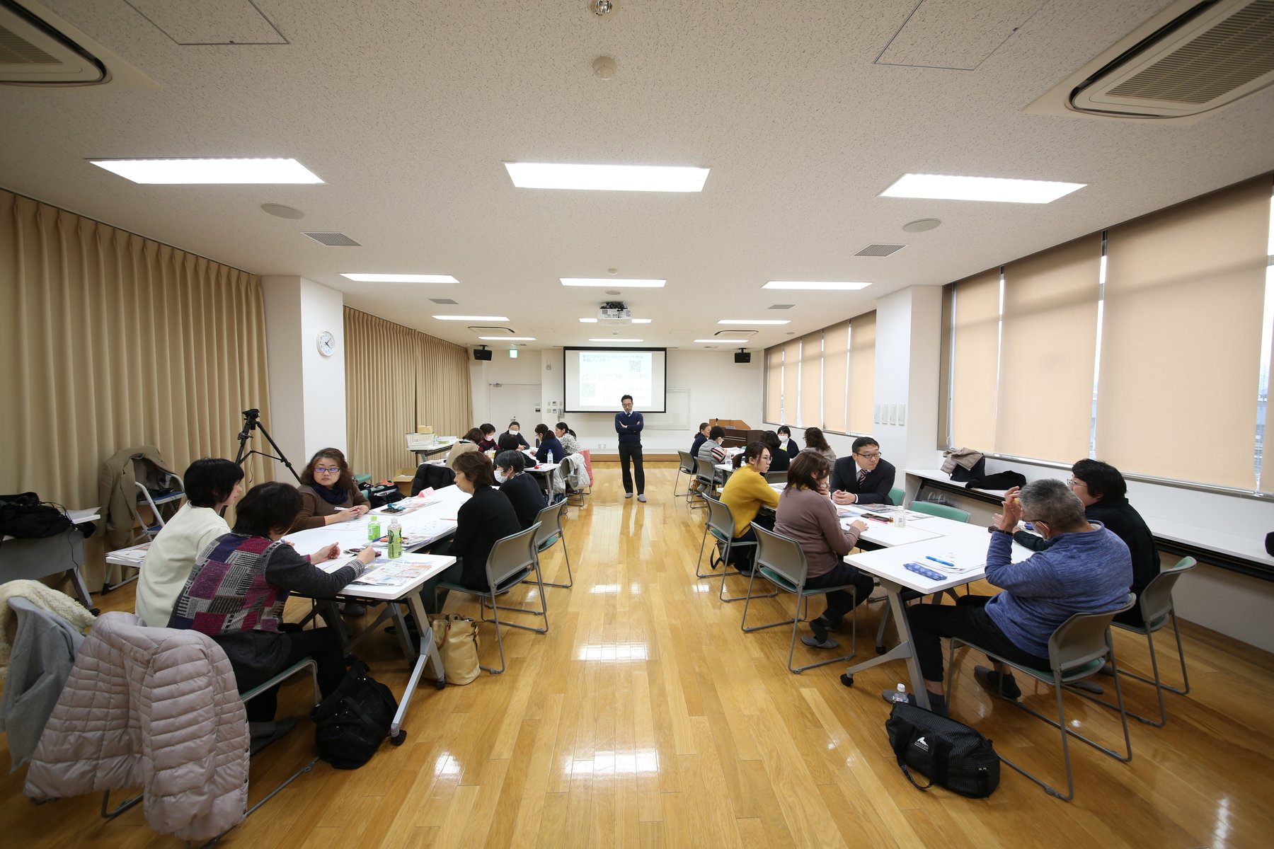 手元を確認しながらフットケア技術を学ぶ実技研修の場面