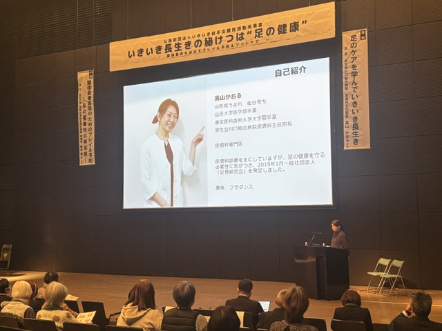 自己紹介スライドを示しながら講演する高山かおる先生