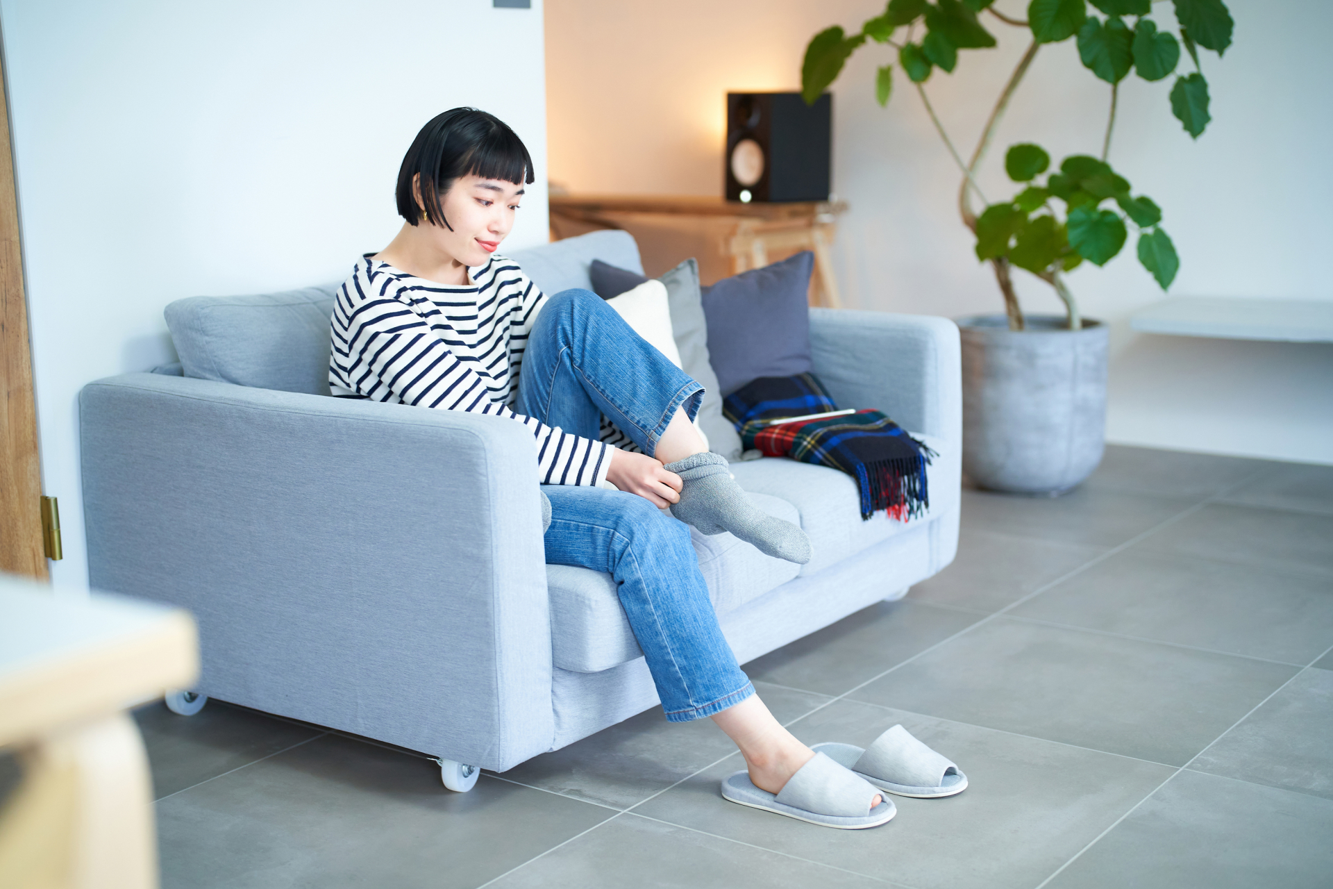 椅子に座って靴下を履くイメージ