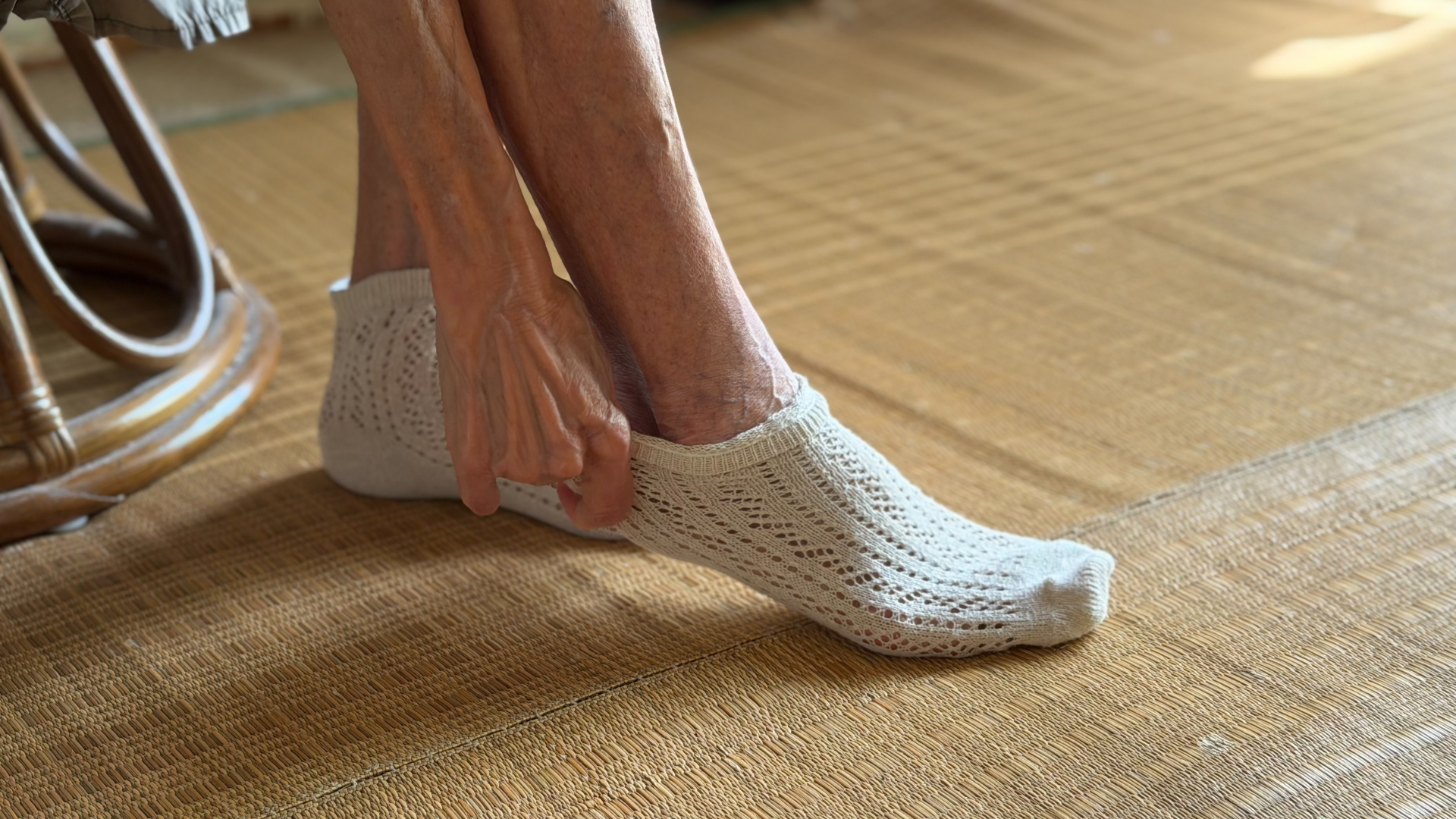 高齢女性が靴下を履く手元