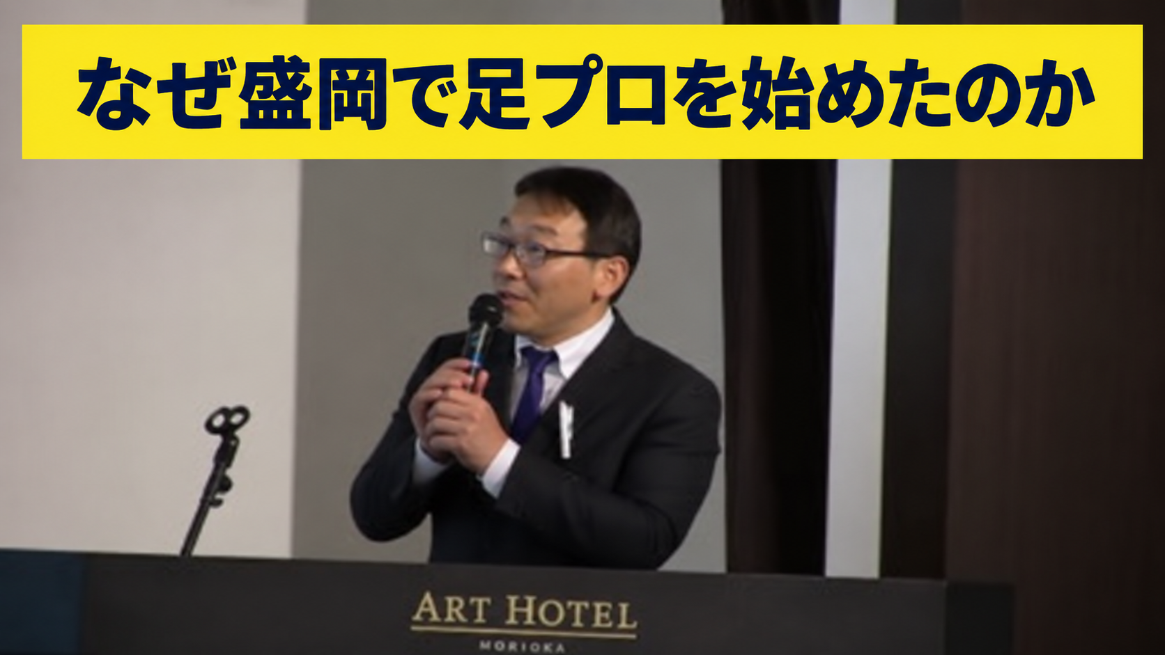 講演中の足プロ代表と「なぜ盛岡で足プロを始めたのか」の黄色帯